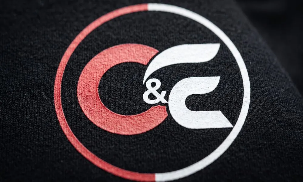Aplicação DTF do símbolo da C&E em camiseta preta de algodão